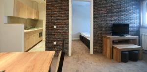 a room with a kitchen with a brick wall at Lonka apartman Kopaonik in Kopaonik +9 photos