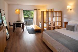 Vila Bicuda Resort في كاسكايس: غرفة نوم بسرير ومكتب وطاولة