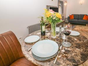 einen Tisch mit Platten und eine Vase Blumen darauf in der Unterkunft Hockerley Cottage in Highpeak Junction