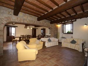 un soggiorno con mobili bianchi e un muro in pietra di Belvilla by OYO Villa San Donato a Galera