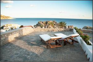a patio with two lounge chairs and the ocean at Jhonathan in Amoopi