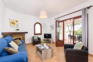 a living room with a blue couch and a fireplace at Villa Amapola by Villa Plus in Santo Tomás