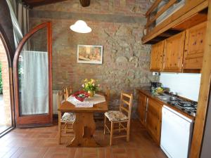 een keuken met een houten tafel in een kamer bij Belvilla by OYO Rosa Tea in Montaione