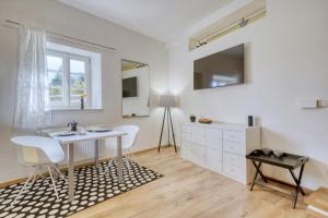 a white room with a table and chairs and a window at Zentral gelegenes Apartment mit Garage und Garten in Caldaro