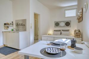 Biały salon ze stołem i łóżkiem w obiekcie Zentral gelegenes Apartment mit Garage und Garten w mieście Caldaro