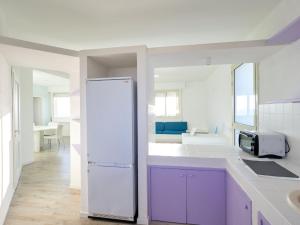 サンタ・クローチェ・カメリーナにあるBelvilla by OYO Casa Zefiroのキッチン(紫色のキャビネット、白い冷蔵庫付)