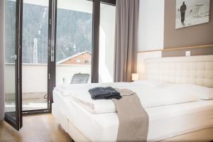 ein Schlafzimmer mit einem weißen Bett und einem großen Fenster in der Unterkunft Appart Gastauer in Sankt Gallenkirch