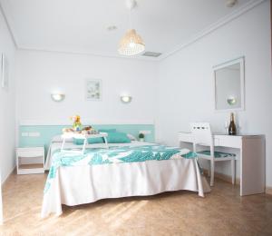 a white bedroom with a bed and a desk at Hotel Blanca Brisa Cabo de Gata in El Cabo de Gata