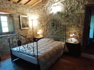 um quarto com uma cama numa parede de pedra em Lovely Cottage in Bagni di Lucca Amidst Fields em Longoio
