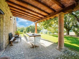 une terrasse avec une table et des chaises sous une pergola en bois dans l'établissement Vintage Villa in Sermugnano with Infinity Pool, à Sermugnano