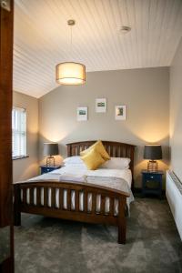 um quarto com uma grande cama de madeira e 2 candeeiros em Noel's Place em Doolin