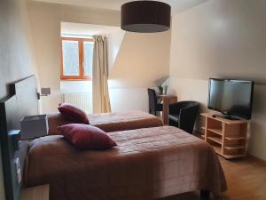 a hotel room with two beds and a flat screen tv at Le Lac Des Moines in Condat