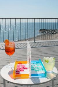 a table with a drink and glasses on a balcony at The Surfside Hotel in Stratford