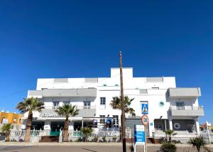 un edificio blanco con palmeras delante en Hotel Blanca Brisa Cabo de Gata en El Cabo de Gata