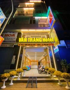 ヴィンロンにあるVân Trang Hotelの車旅のホテルを読む看板のある建物