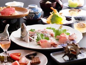 une table pleine d'assiettes de nourriture sur une table dans l'établissement Seikiro Ryokan Historical Museum Hotel, à Miyazu