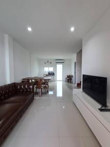 a living room with a couch and a flat screen tv at YYK Homestay in Ban Khlong Krang