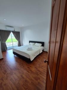 a bedroom with a bed and a wooden floor at YYK Homestay in Ban Khlong Krang