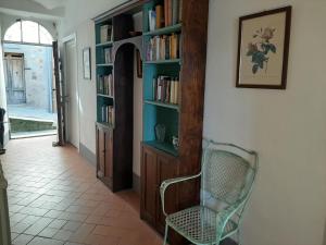 a hallway with a chair and book shelves with books at Belvilla by OYO Vista dalla Terrazza in Montecastelli