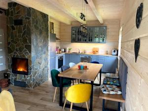 uma pequena cozinha com uma mesa e uma lareira em Górskie Formy - drewniany dom w górach z balią em Leszczyniec