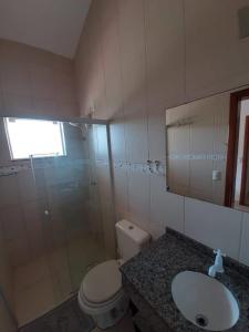 uma casa de banho com um WC, um lavatório e um chuveiro em Cantinho da Barra em Imbituba