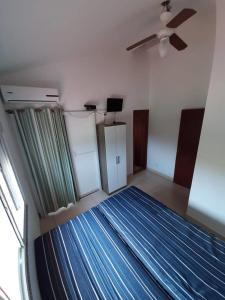 - une chambre avec un lit et un ventilateur de plafond dans l'établissement Cantinho da Barra, à Imbituba