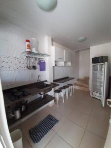 uma cozinha com um monte de mesas e cadeiras em Cantinho da Barra em Imbituba