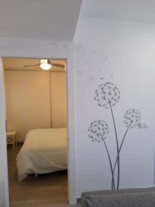 a bedroom with a wall with a drawing of flowers at Apartamento Molinos del Río in Murcia