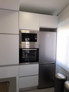 uma cozinha com um micro-ondas e um frigorífico em Apartamento Molinos del Río em Múrcia