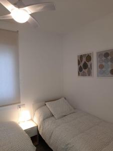 Apartamento Molinos del Río في مورسية: غرفة نوم بسريرين ومروحة سقف