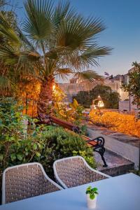 a table and chairs in front of a palm tree at Heritage Villa Nobile in Dubrovnik