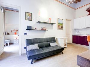 a living room with a black couch and a kitchen at Mansion in Lucca near Via Fillungo in Lucca