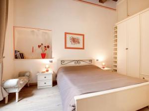 a bedroom with a bed and two tables and a chair at Mansion in Lucca near Via Fillungo in Lucca
