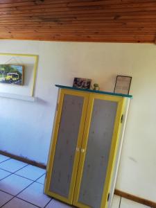 a yellow door in a room with a wooden ceiling at le p'ti blanc des "o" in Salazie