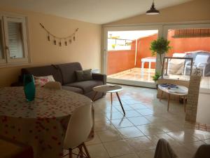 a living room with a table and a couch at La tropezienne, Duplex 73 m2, 100 m du port, climatisation, grande terrasse in Sanary-sur-Mer