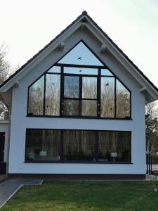 una casa con ventanas grandes. en Uns Langhus en Fuhlendorf