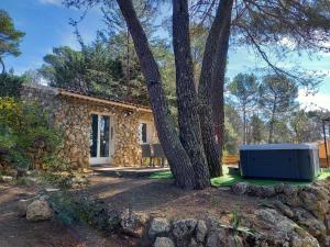 uma casa de pedra com uma árvore em frente em GITE AVEC SPA JACUZZI au cœur de Provence Côte d'Azur em Saint Antonin du Var