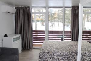 - une chambre avec un lit et une grande fenêtre dans l'établissement Lagoon, à Juodkrantė