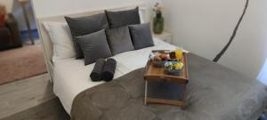 un sofá blanco con almohadas y una mesa con fruta. en Apartment City Center, en Rovinj