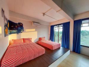 1 dormitorio con 2 camas y ventana en Moon Village Khaoyai Holiday Home, en Pong Talong