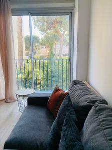 um sofá numa sala de estar com uma grande janela em GM Studio em La Grande-Motte