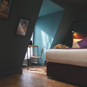 a bedroom with a bed and a table and a chair at Duke Street Boutique Hotel in Liverpool