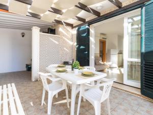 un comedor blanco con una mesa y sillas blancas en Apartment Simona, en Torre Suda