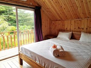 1 dormitorio con 1 cama con toallas en CHEZ MARVA Grande Villa COCO 3 à 12 personnes, en La Digue