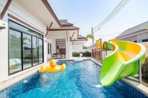 una piscina con un pato inflable de goma en una casa en บ้านอิ่มสุข พลูวิลล่า ชะอำ en Hua Hin