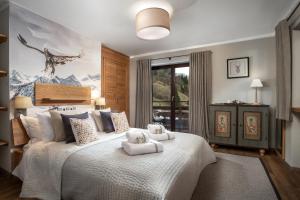 a bedroom with a white bed with a deer painting on the wall at Chalet Zell by Chalet Alp Lux in Zell am See