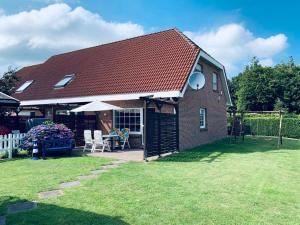 ein Haus mit einem Tisch und Stühlen im Hof in der Unterkunft 50059 Ferienhaus in Altfunnixsiel