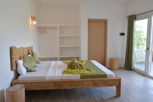 a bedroom with a large bed with green pillows at La Base Beach Hotel in Kiwengwa