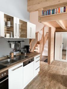 a kitchen with white cabinets and a sink at Aschauer Ferienwohung (DE Schönau am Königssee) - Aschauer Michaela und Stefan - 36518 in Schönau am Königssee +14 photos