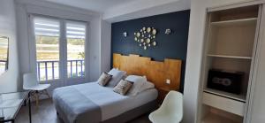 a hotel room with a bed and a balcony at Le Relais Du Lac in Hossegor